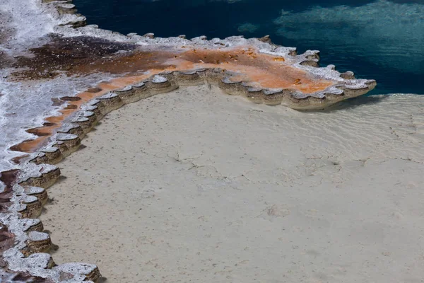 怀俄明州黄石公园明亮的蓝色热水带着独特的细菌和矿物质形成了微妙的边缘 — 图库照片