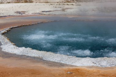 Yellowstone Doğal Parkı 'nda beyaz kenarlı İbikli Havuz' un içindeki derin mavi kaynar su..