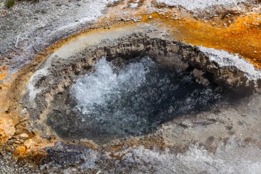 Wyoming 'deki Yellowstone Ulusal Parkı' ndaki yeraltı jeotermal aktivitelerinden kaynaklanan kaynar suyla dolu bir göz şeklindeki açıklık..