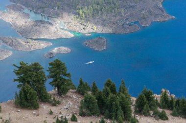 Bir tur teknesi, Güney Oregon Şelale Dağları 'ndaki muhteşem mavi ve derin Krater Gölü' nde insanları gezdiriyor..