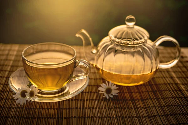 Glass cup and teapot sunset background — Stock Photo, Image