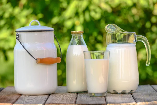 Vaso y jarra de leche fresca sobre mesa de madera — Foto de Stock