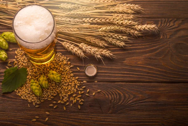 Bier im Becher auf Holztisch — Stockfoto