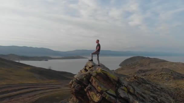 Homme se tient sur le rocher, drone vole autour — Video