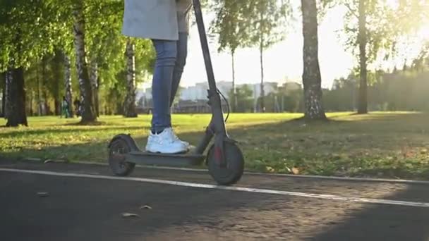 Mädchen fährt E-Scooter im Stadtpark — Stockvideo