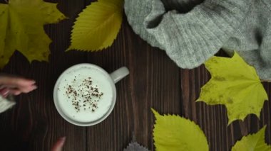 Kız bir fincan kahveyi ahşap masadan alır