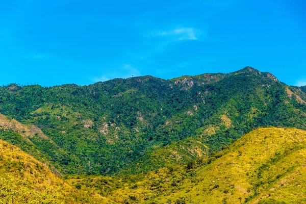 Santiago de Cuba: Beautiful Cuban countryside. Sierra Maestra mountains with green forest and clear blue sky seen with intermittent white clouds and bright sunlight