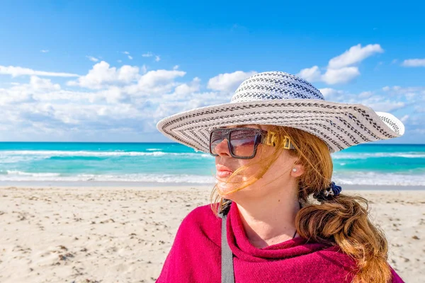 Beautiful middle age tourist woman in Varadero beach, portrait of lady wearing a hat.