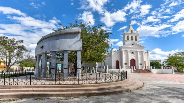 Santa Clara, Villa Clara, Cuba-January 20, 2019: \'El Carmen\' park with the city foundational monument in the first plane. The Catholic church of the same name in the background. The park is a National Monument