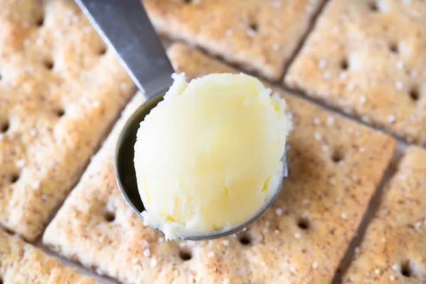 Butter scoop over soda crackers