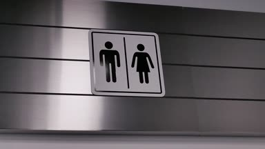Erkek ve kadın tuvalet logosunun yanında duvar hareket