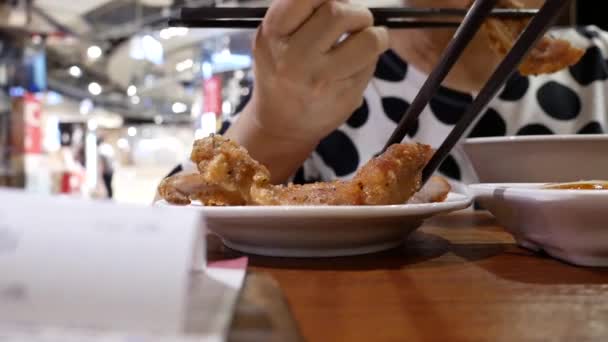 中餐厅内食用油炸猪肉和食物的人的运动 — 图库视频影像