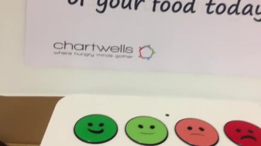 Kadının onun okul kafeteryasında yemek zevkime gülümseme düğmesine basarak hareket