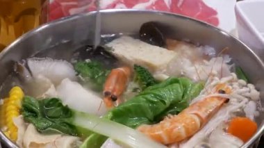 İnsanların gıda güveç içinde Çin restoranı karıştırarak yemek çubuğu kullanarak hareket