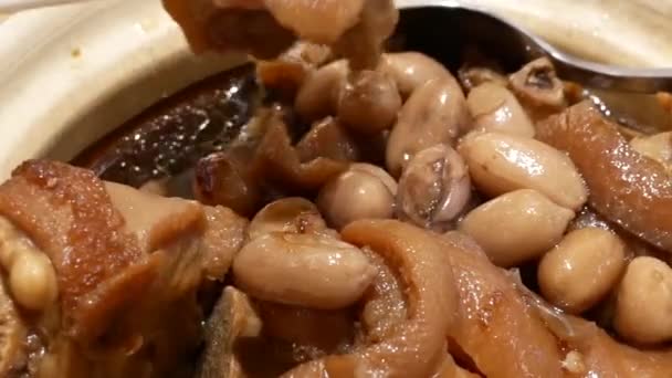 Bewegung von Menschen, die geschmortes Schweinefleisch und Erdnüsse auf dem Tisch im chinesischen Restaurant essen 