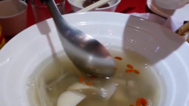 İnsanlar dökülen beyaz mantar ve wolfberry çorba kupa Çin restoranı içinde hareket