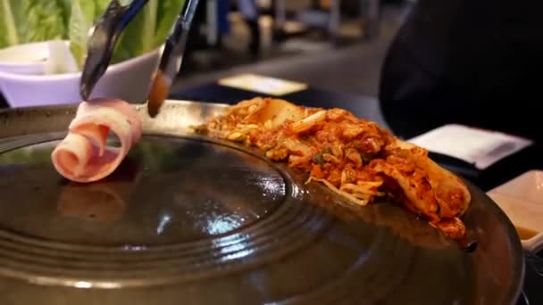 韩国餐厅内餐桌上的女服务员为顾客烹饪 Bbq 肉的运动 — 图库视频影像