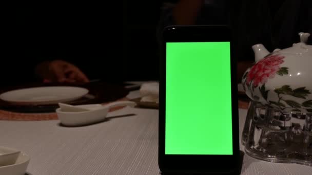 绿屏手机的运动与模糊的人在餐厅内喝茶 — 图库视频影像