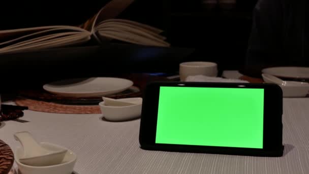 Rörelseoskärpa Grön Skärm Telefon Med Människor Tittar Menyn Inne Restaurangen — Stockvideo