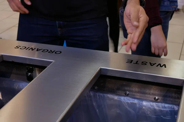 Close-up mensen gooien prullenbak naar de vuilnis kan in winkelcentrum — Stockfoto
