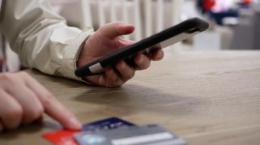 Akıllı telefondan hediye almak için kredi kartı numarası yazan kadının hareketi 