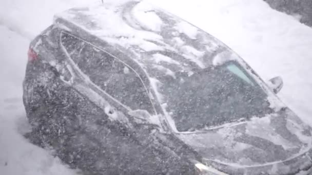 寒い吹雪の冬の日に彼女の車の風防窓から雪や氷を掃除する人々のスローモーション — ストック動画