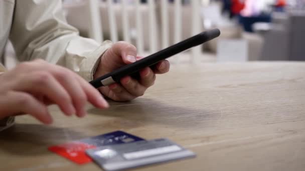 スマートフォンでギフトを購入するためのクレジットカード番号を入力する女性の動き — ストック動画