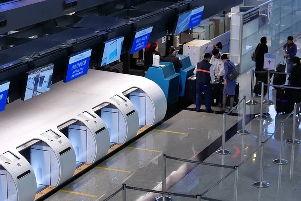 Κορυφαία βολή του τμήματος απόθεσης τσάντα και επιβάτες που πηγαίνουν στην China αερομεταφορέα check in γραφεία στο εσωτερικό της Ταϊβάν αεροδρόμιο — Φωτογραφία Αρχείου