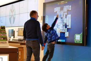 Microsoft mağazasında tv ekranında xbox oyunu oynayan baba ve çocukların hareketi
