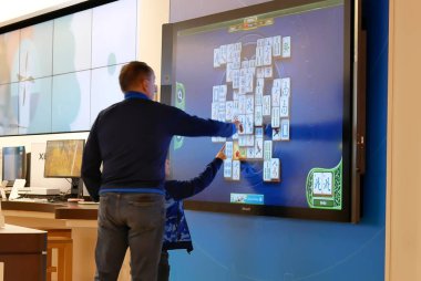 Microsoft mağazasında tv ekranında xbox oyunu oynayan baba ve çocukların hareketi