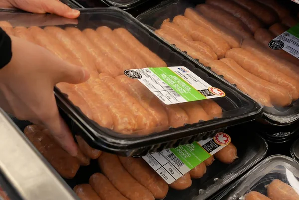 Motion of woman buying sausage inside Walmart store — ストック写真