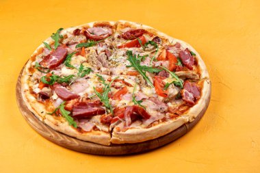 Sarı arka planda et ve peynir li pizza