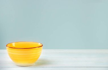 Seramik boş, ahşap bir masada sarı kase.