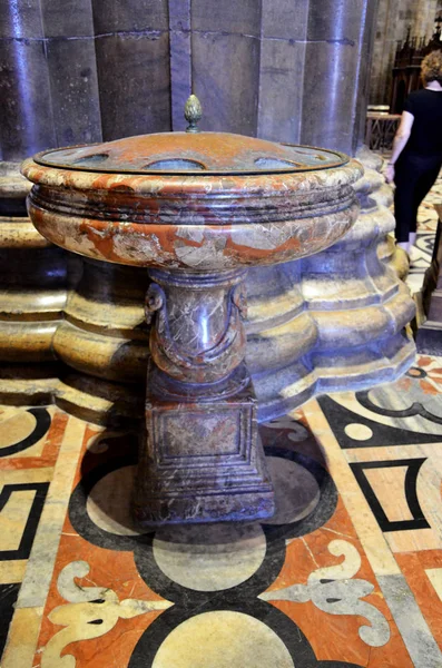 Baptismal font by a column in Milan Cathedral