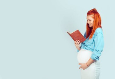 İçinde yüksek sesle göbek ve açık mavi renkli izole gülümseyen Bebek Bakımı kitap okuma içerik genç kadın. Karışık ırk modeli, latin Latin asıllı İrlandalı kadın
