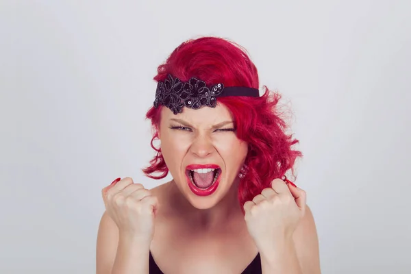 Portrait angry young woman screaming fists clenched. Red head curly bob hairstyle girl isolated light gray grey white background. Mixed race latin hispanic caucasian fashion model