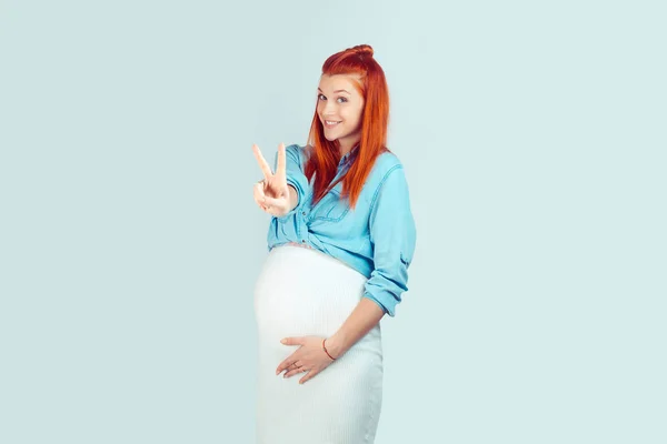 Hübsche Ingwerfrau Schwanger Hält Zwei Finger Der Hand Und Lächelt — Stockfoto