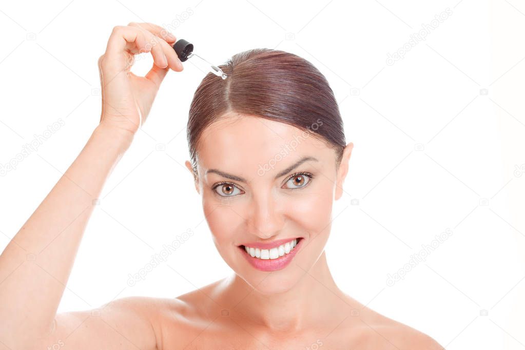 Hair Serum For woman. Woman applying serum essence essential oils to her hairline for growth against gray hair solution smiling happy isolated on white. Positive face expression mixed race latina girl