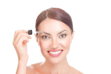 Kaş kadın Serum için. Kadın kaşlarını büyüme ve güçlü saç çözüm üzerinde beyaz izole mutlu gülümseyerek için serum özü yağlar uygulamak. Yarış latina kız karışık olumlu yüz ifadesi