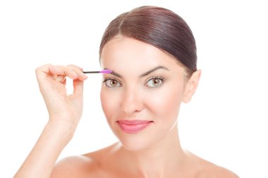 Güzel bir kadın onun kaş fırçalama. Seni kameraya gülümseyen holding maskara portre kız yakın yakınındaki beyaz arka plan üzerinde izole onun Kaş fırçası. Karışık yarış latin Brezilyalı beyaz model