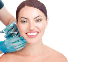 Gülümseyen güzel kadın hazır serum anti-aging yanak içinde botulinum toksin enjeksiyon yanağından sahip kız yüz huzurlu güzel model beyaz arka plan üzerinde doktor el Mavi eldiven tutun şırınga tarafından vurdu