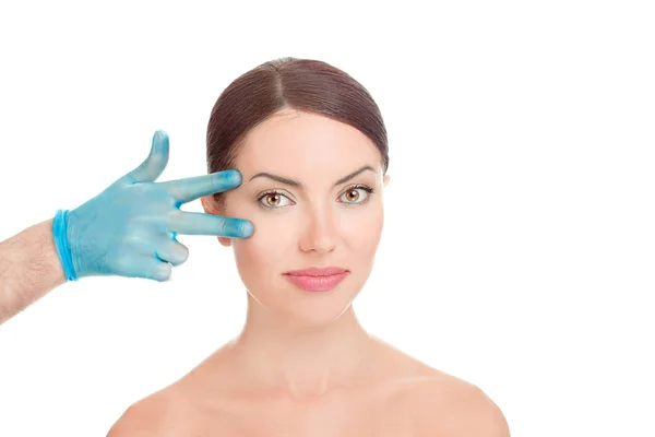 下睑袋 美丽的中年39岁的妇女准备眼睑升降机整形外科医生手里拿着蓝手套点手指到她的眼睛上白 美化理念 — 图库照片
