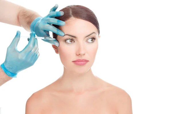妇女有抗皱 抗衰老血清拍摄周围的眼睛整形外科医生的手在蓝色手套持有注射在白色背景脸上 没有皱纹的妇女的脸隔离 — 图库照片