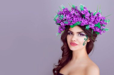 Açık mor renkli izole çiçek kafa bandı giyen güzel genç kadın. Size gülümseyen biraz hayalifener şirin güzel kıza baktığını kafasına çiçeklerin mor lavanta çelenk.