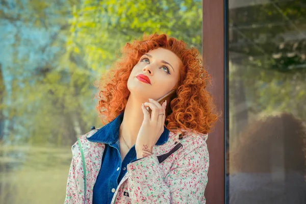 Rahatsız kadın konuşmak telefon ve gözleri ayakta arka plan üzerinde şehir dışında konuşma tarafından sıkılmış alınıyor. Negatif insan duyguları ifade duygu yüz