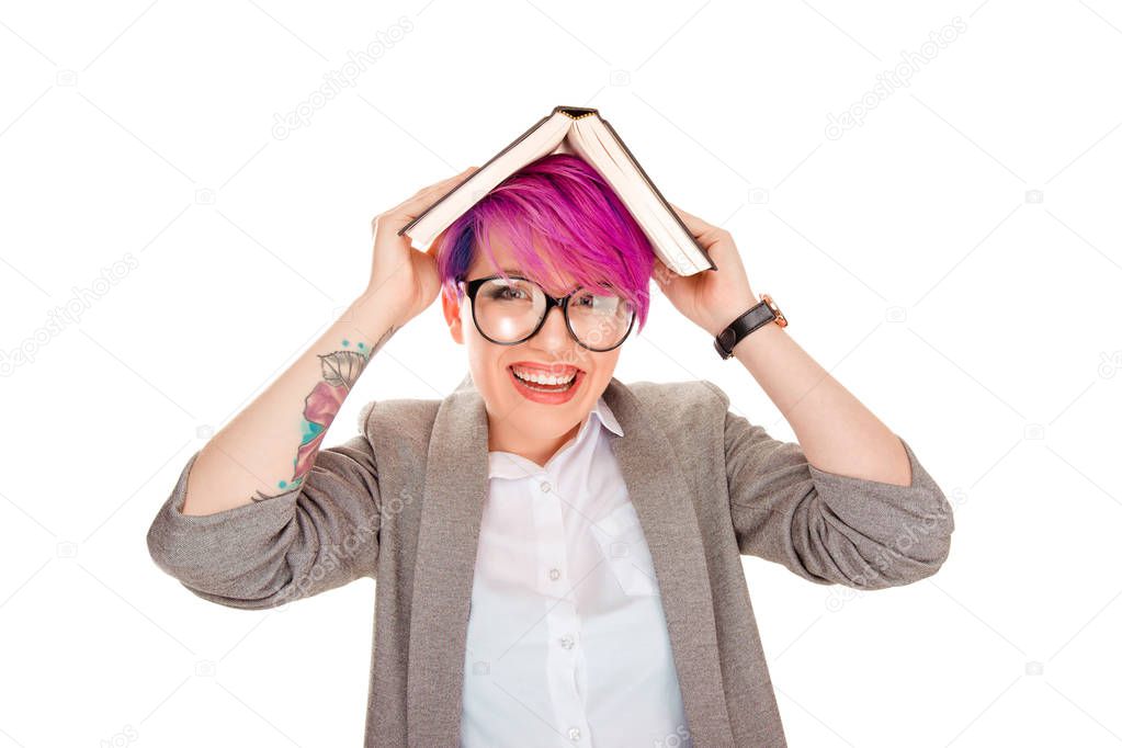 woman in eyeglasses laughing with book on her head as a roof