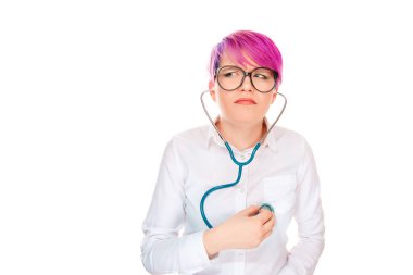 Young expressive millennial woman with short hair in pink dye listening heartbeat with stethoscope looking doubtfully away on white background clipart