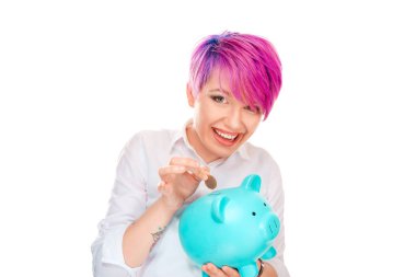 Mavi para tasarrufu ve beyaz arka plan üzerinde izole kamera gülümseyen kumbara para ekleyerek kısa pembe saç modeli ile neşeli genç kadın 