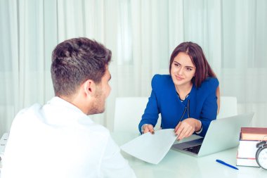 Gülümseyen genç kadın için boşluk veya patron adam aday coworking için office belgesindeki gösteren kağıt çalışma masasında. Çift meslektaşları arkadaşları office kavramı masada oturan iş başında. 