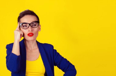 Portre portre kadın parmağı Tapınağı kafasına, derin bir şey hakkında düşünüyor, bakılması, sarı zemin üzerine izole. Sarı gömlek ve mavi elbise modeli. İnsan tarafsız yüz ifadesi, duygu.